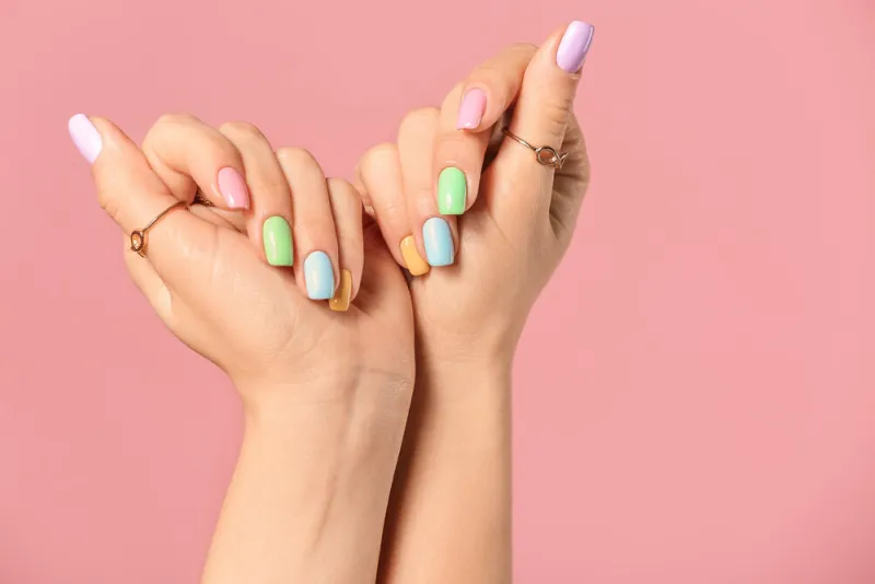 hands of young woman with beautiful manicure on color background