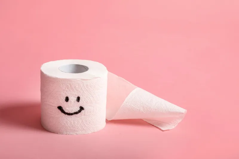 toilet paper roll with happy smile on pink background