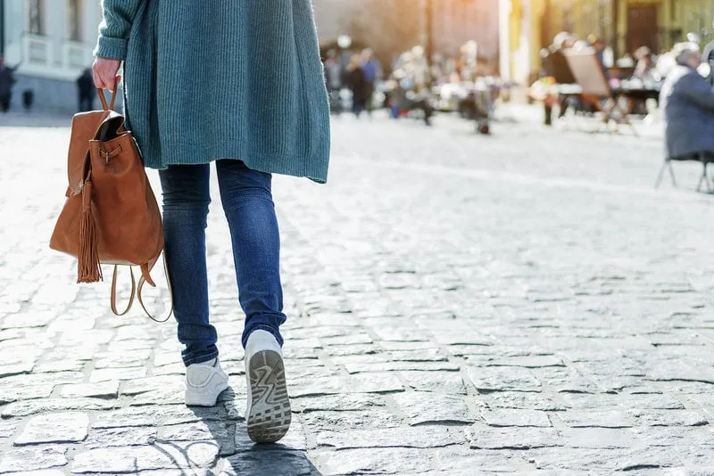 close up of female legs walking on street young woman is carrying leather bag copy space