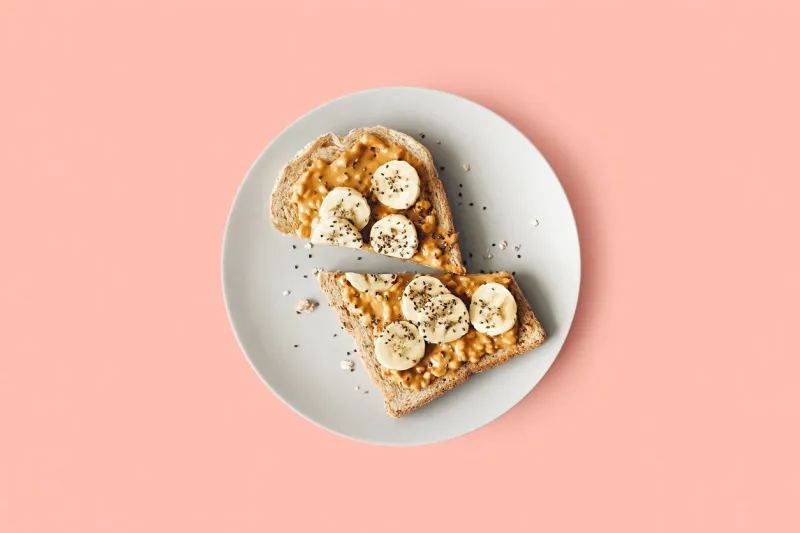 peanut butter chia seed banana toast for breakfast on a pink background, healthy snack, top view