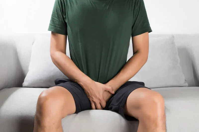 asian man wants to pee and is holding his bladder