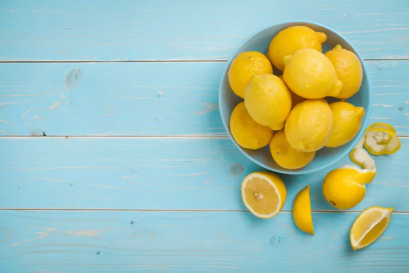bol avec des citrons frais sur la vue de dessus de fond en bois bleu