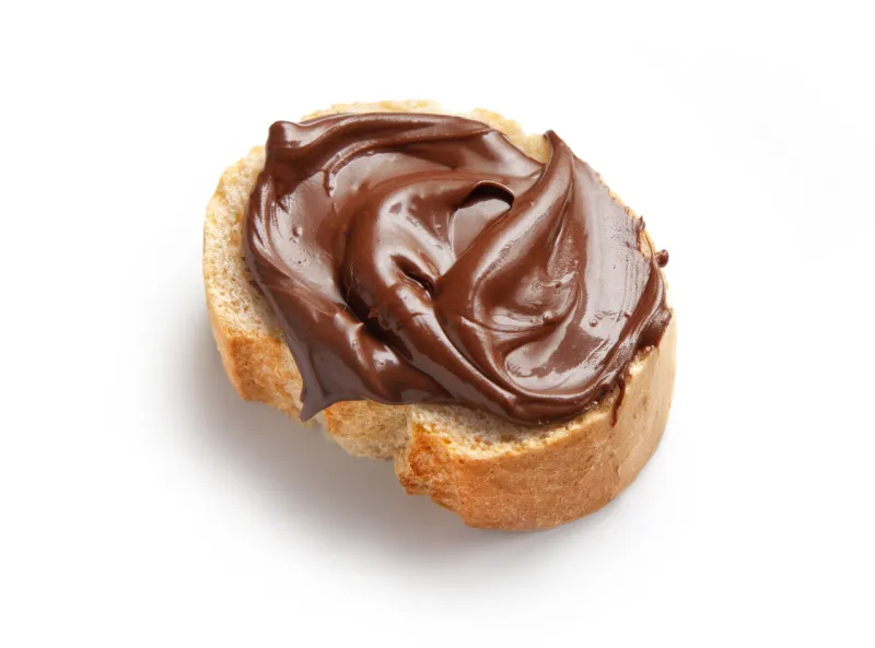 toasted bread slice with chocolate hazelnut cream isolated on white background, top view