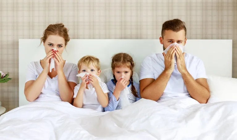 colds and viral diseases family with runny nose and fever in bed at home