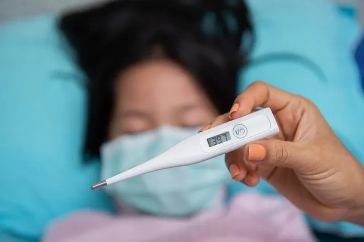 close-up mother hand holding thermometer taking child's temperature