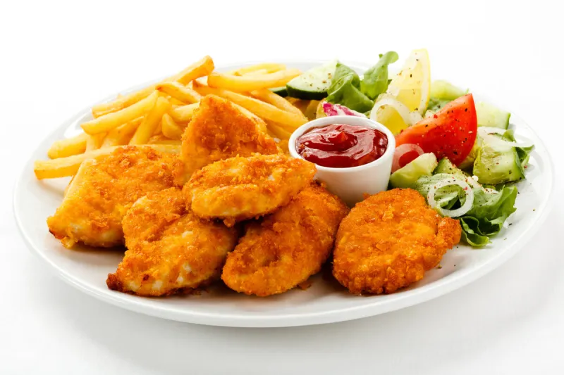 fried chicken nuggets, french fries and vegetables