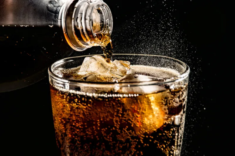 poured beverrage into a glass with ice,cola drink is fizzy