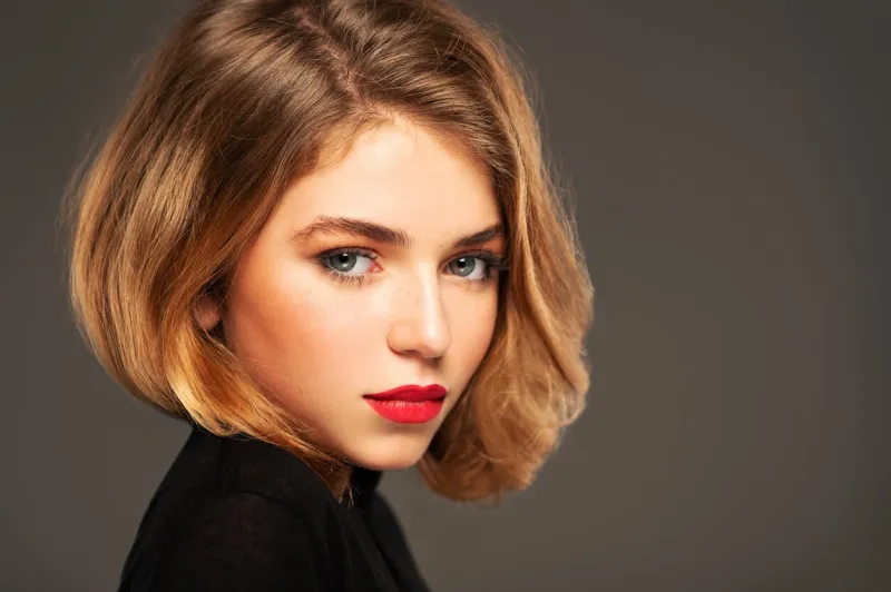 closeup portrait of an young adult girl with medium length hair photo of a fashion model posing at studio pretty young woman with red lips looking at camera beauty portrait