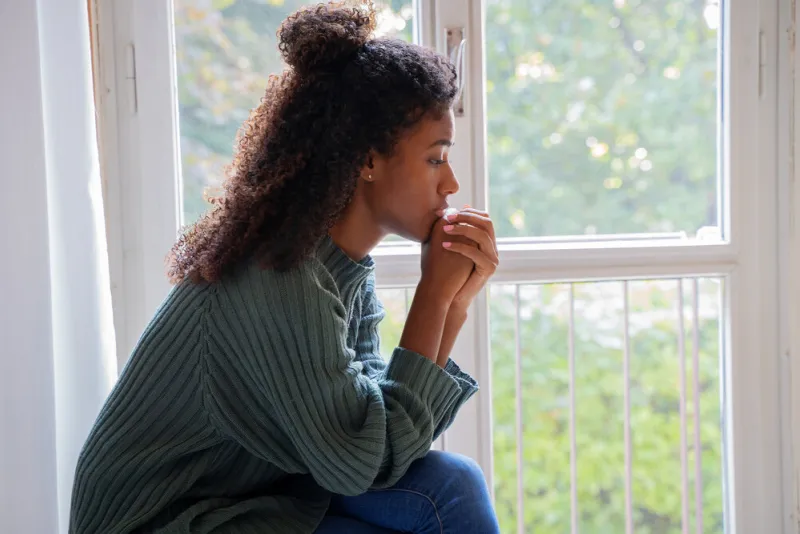 black woman feeling depression symptoms alone at home