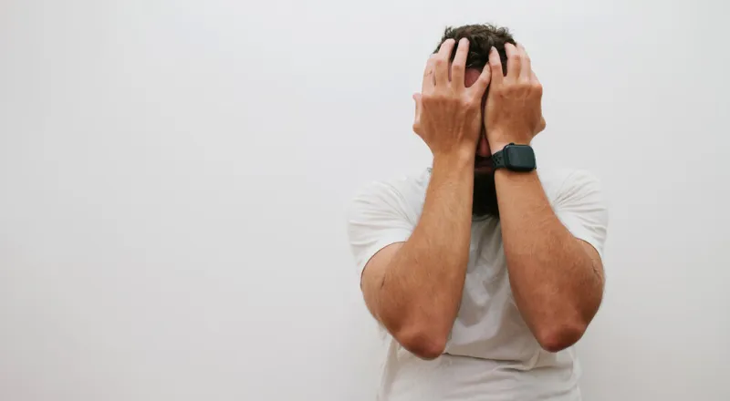 homeless man drug addict and alcoholic sitting alone and depressed on the street, feeling anxious and tormented, social documentary concept