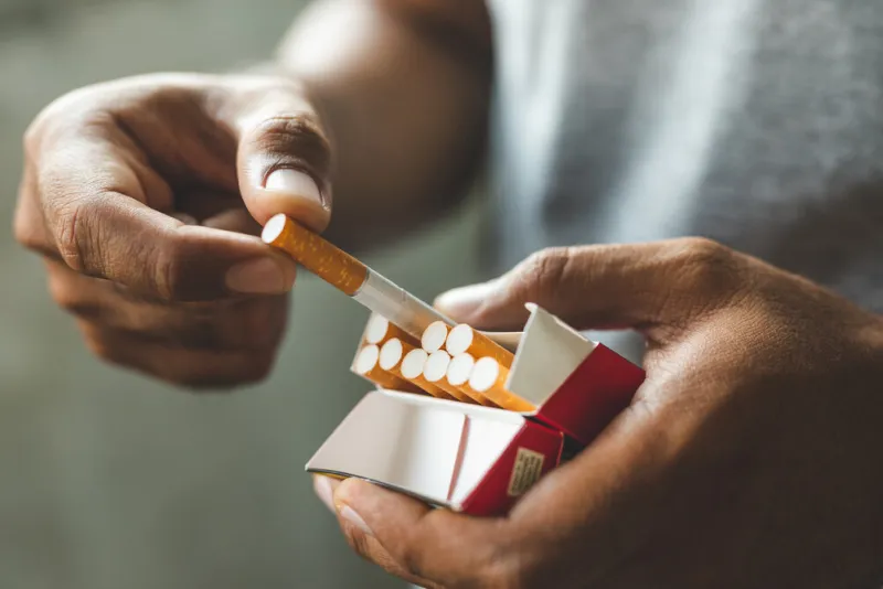 close up male hand holding a cigarette