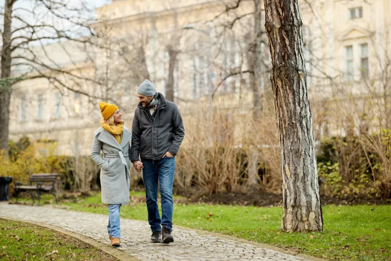 romantic couple enjoying a walk in the park holding hands