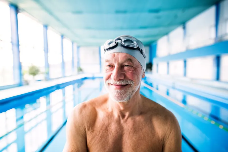 senior man in an indoor swimming pool active pensioner enjoying sport