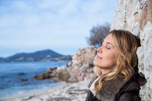 portrait of a woman on the beach in winter with closed eyes