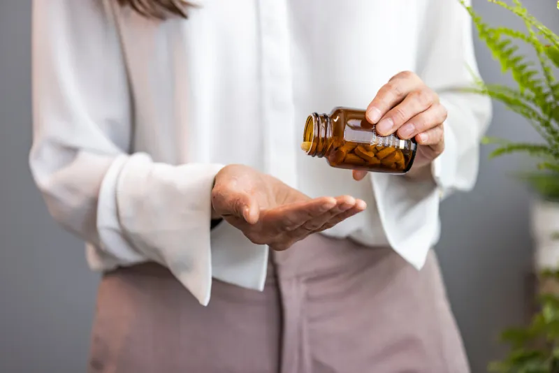 woman taking tablet with glass of fresh water close up of woman holding a glass of water and medication in her hand sick young woman taking pills at home