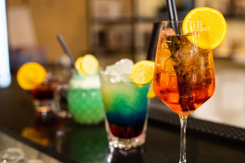 composition of various cocktails on the counter in strong colors and fruit on the head