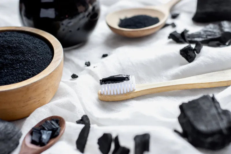 black charcoal toothpaste with finely ground charcoal is placed on a white cloth