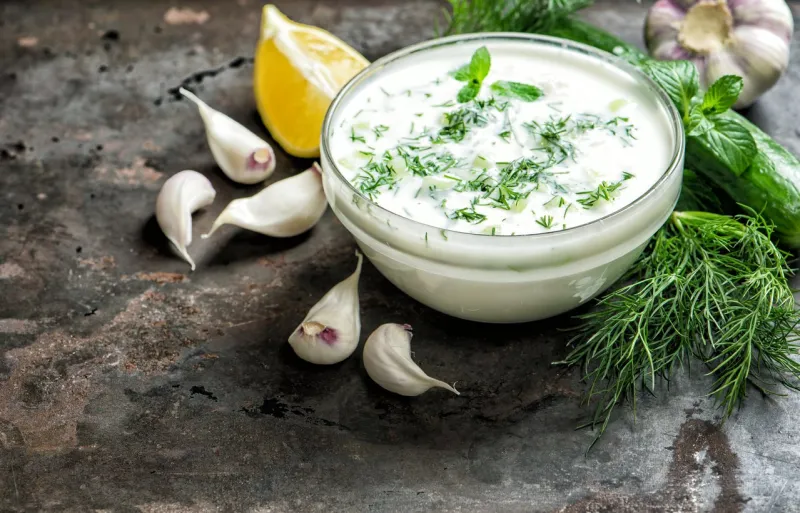 tzatziki sauce with ingredients cucumber, garlic, dill, lemon, mint food background