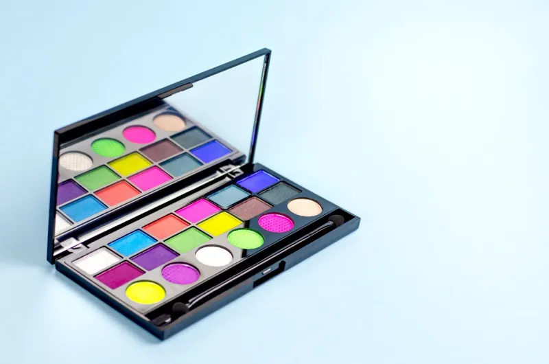 neon palette of shadows on a blue background women's cosmetics