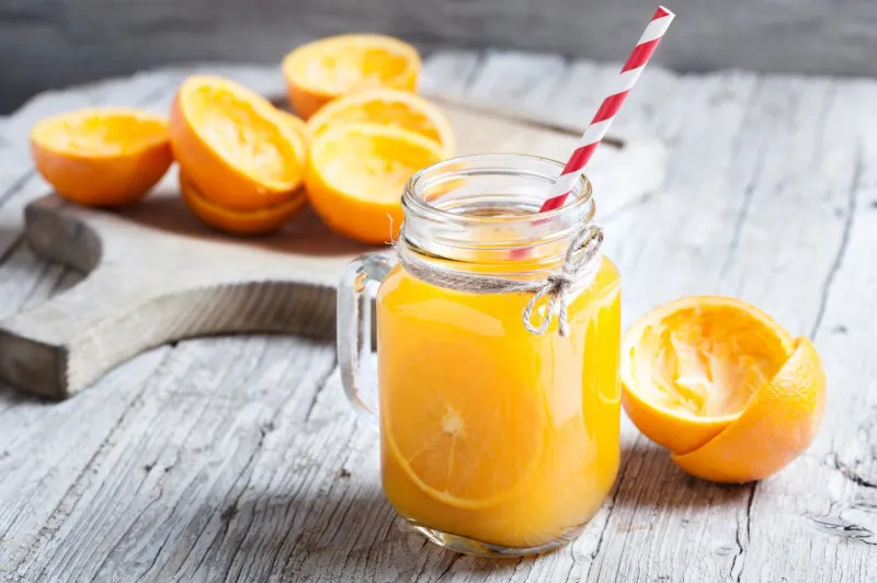 orange juice squeezed in glass jar with fund rustic
