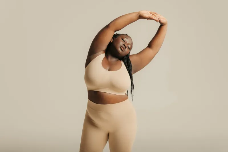 attractive african plus size woman in underwear radiating self-love while standing on studio background