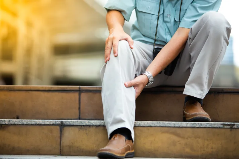 unhappy senior man suffering from knee ache travel and tourism concepthealth problem and people concept