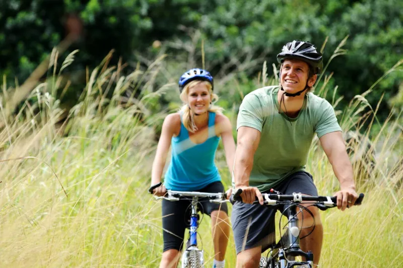 happy couple riding bicycles outside, healthy lifestyle fun concept