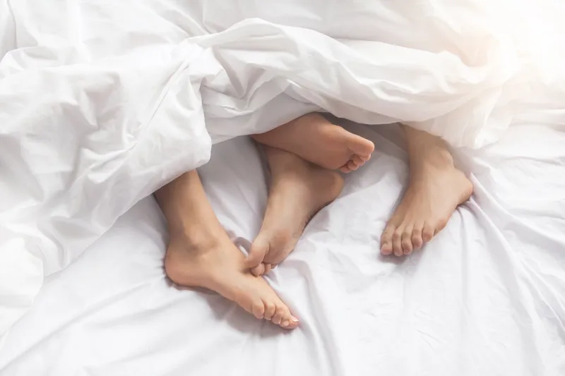 young couple man and woman intimate relationship on bed feet