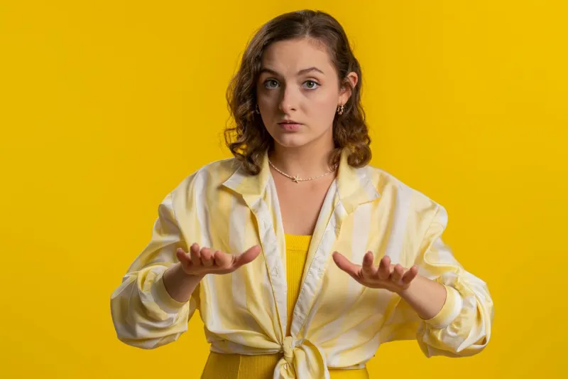 hey you, be careful, slowly young woman warning with admonishing finger gesture, saying no, be careful, scolding and giving advice to avoid danger disapproval sign girl isolated on yellow background