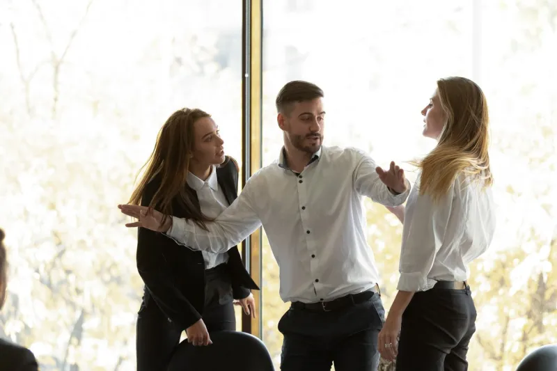 two businesswomen having conflict at group meeting in boardroom, standing starting fight showing negative attitude colleague try to stop scuffle, confrontation, struggle for leadership at work concept