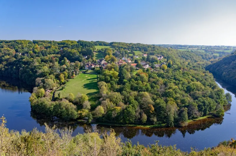 an overlooking view of the beautiful horseshoe bend of the creuse river at fall, dominated by the village of badecon-le-pin