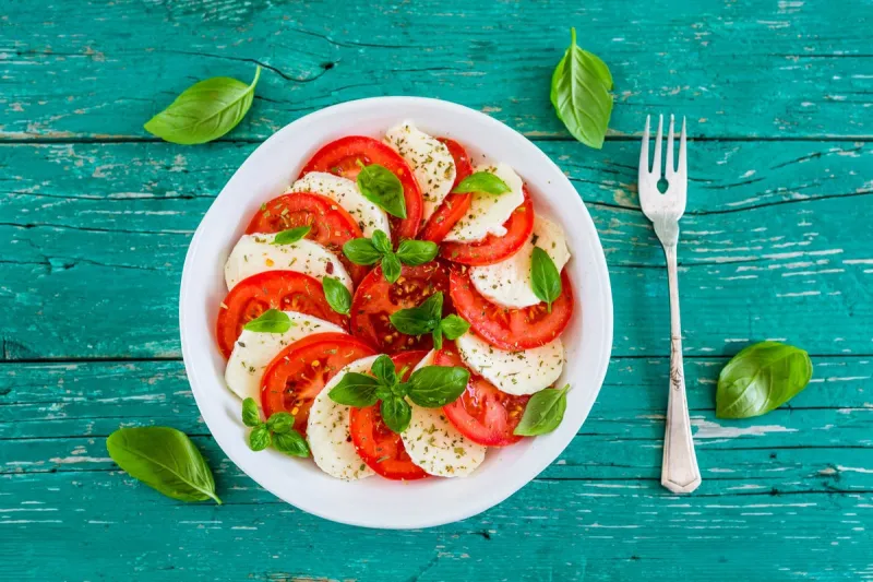 delicious caprese salad with ripe tomatoes and mozzarella cheese