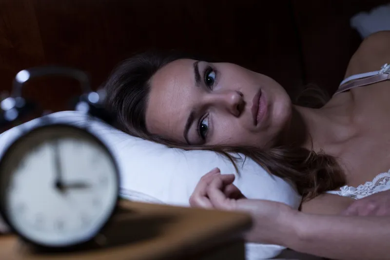 woman lying in bed suffering from insomnia
