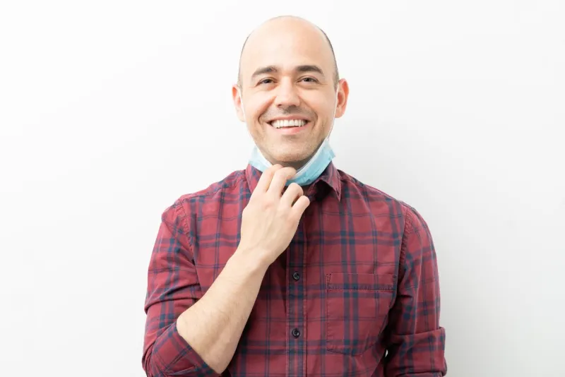 relieved caucasian man taking off surgical mask after the passing of covid19 pandemic