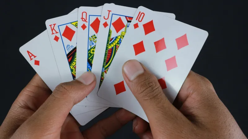 hand with poker cards isolated on dark background