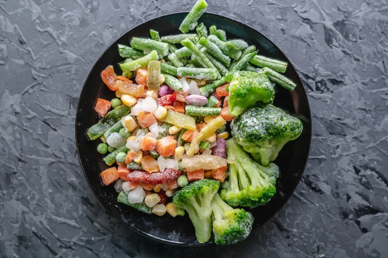 plate of frozen vegetables on a gray table concept of saving time on cooking dinner and convenient storage of ready made frozen dishes