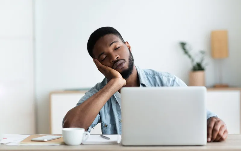 exhausted african american worker felt asleep at workplace, panorama with copy space