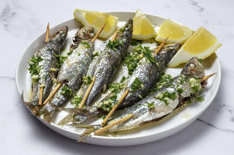 homemade grilled sardines with garlic, olive oil, fresh parsley and lemonhealthy food concept