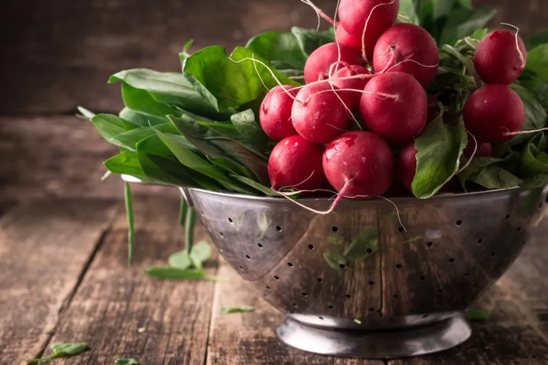 fresh vegetables in a metal colander ,healthy food on a wooden vintage table