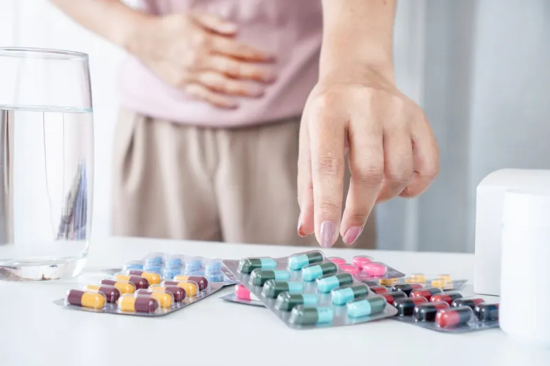 close-up of woman's hand taking an antibiotic pill for treating stomachache , dahlia infection