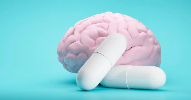 white pills on blue background with brain model