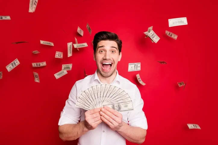 photo of overjoyed nice good attractive, handsome man having won lottery while isolated with red background