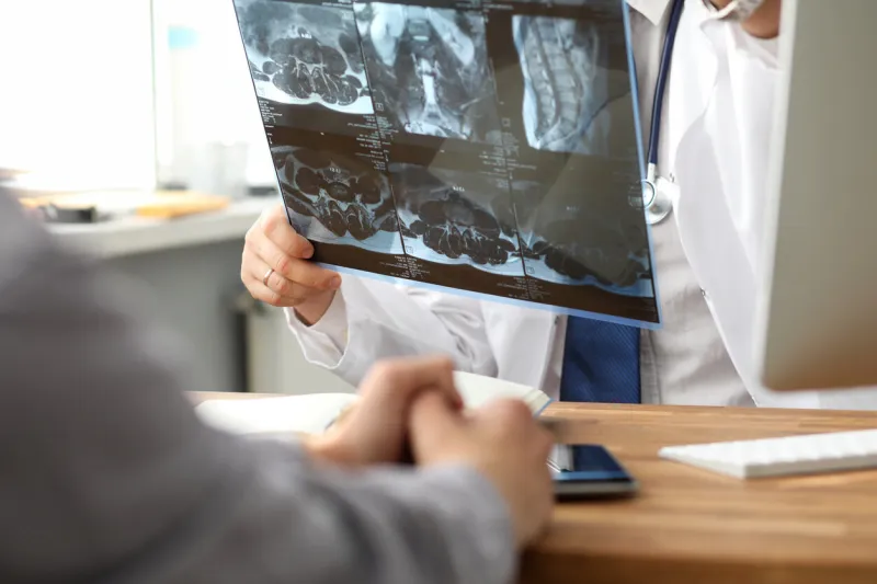 close-up of male hands showing radiograph to patient and explaining diagnosis ill man visiting doctor digital image in different projections healthcare and clinic concept