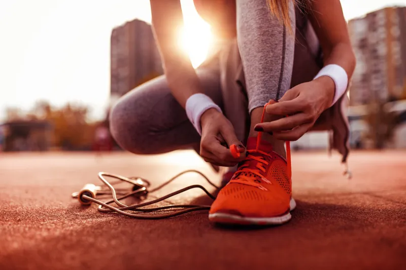 female runner tying her shoes and preparing for a jogging
