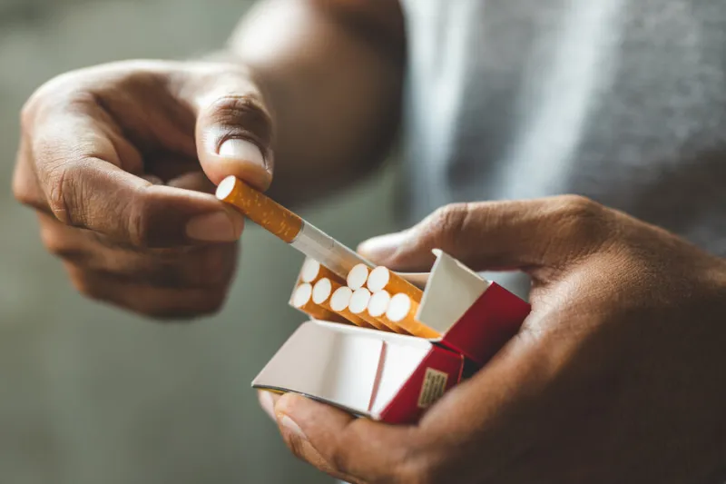 close up male hand holding a cigarette