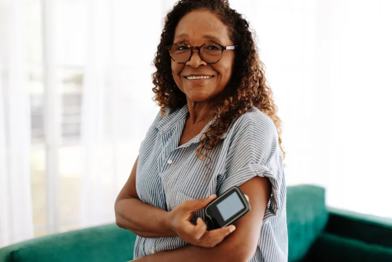 portrait of a woman using continuous glucose monitoring to manage her diabetes at home mature woman using the latest health technology to measure and keep her blood glucose levels under control