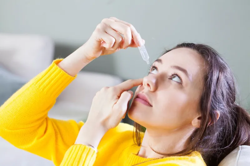 young woman uses eye drops for eye treatment redness, dry eyes, allergy and eye itching