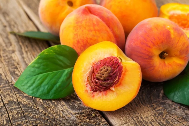 fresh peaches on wood background