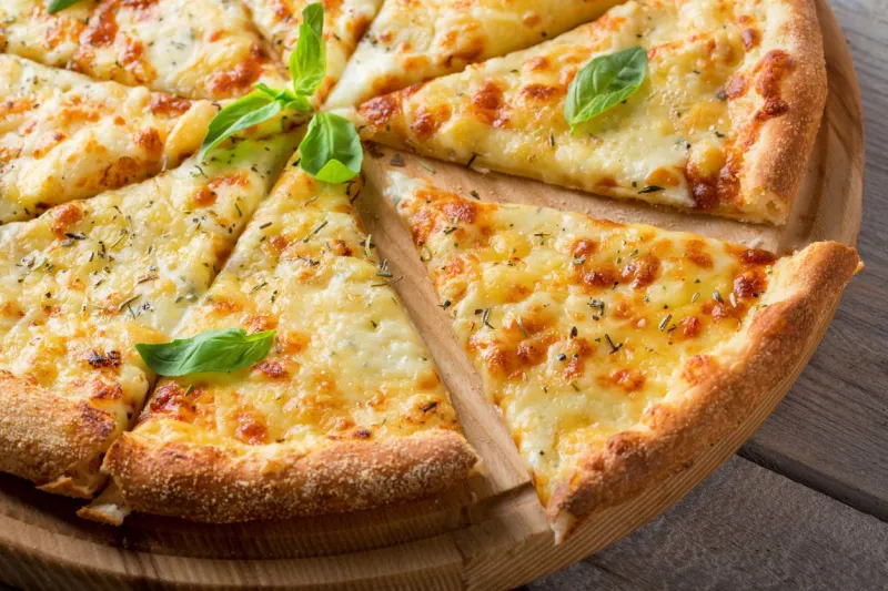 pizza four cheeses on bamboo bottom on wooden table close-up