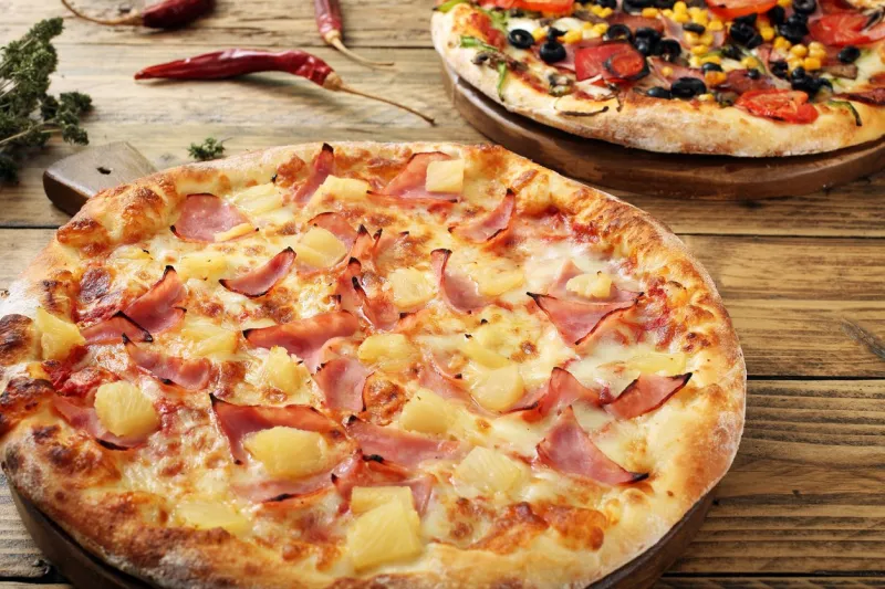 close up hawaiian pizza rustic table background